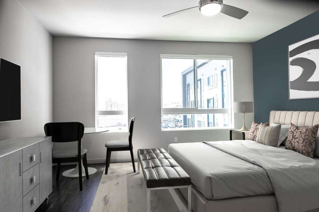 Modern upscale Reno vacation rental bedroom with large windows, stylish decor, and full amenities for a golf getaway.